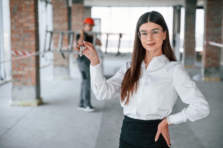 Woman holding keys in unfinished building