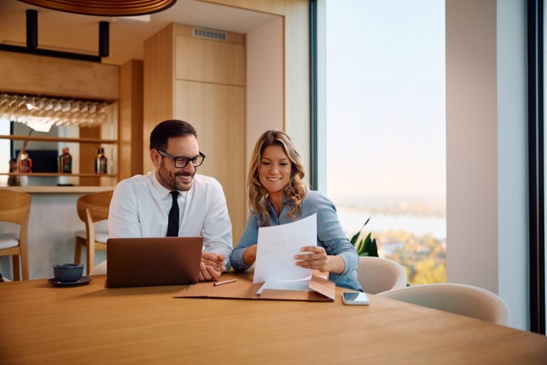 Coworkers discussing documents in modern office.