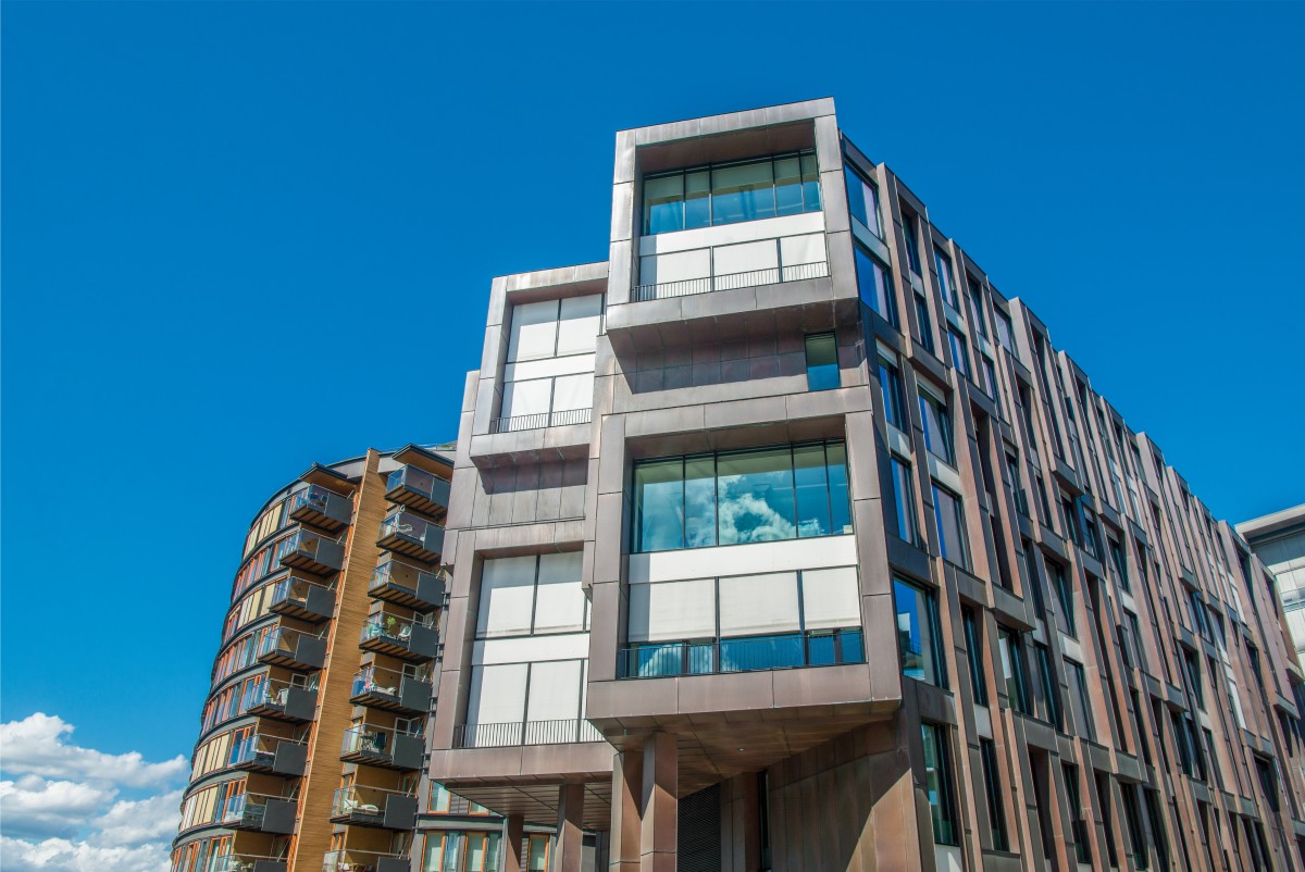 Modern apartment buildings against clear blue sky