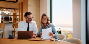Coworkers discussing documents in modern office.